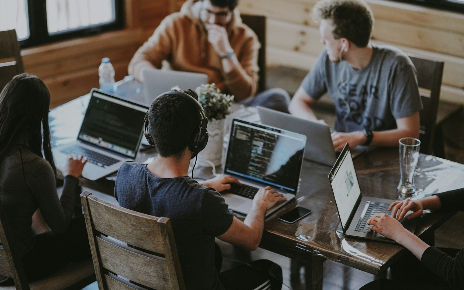 Engineers collaborating around laptops at a shared table