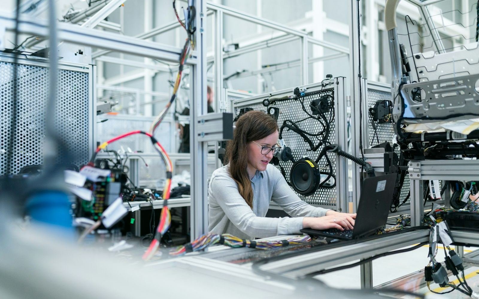 Engineer working on a laptop on a manufacturing floor